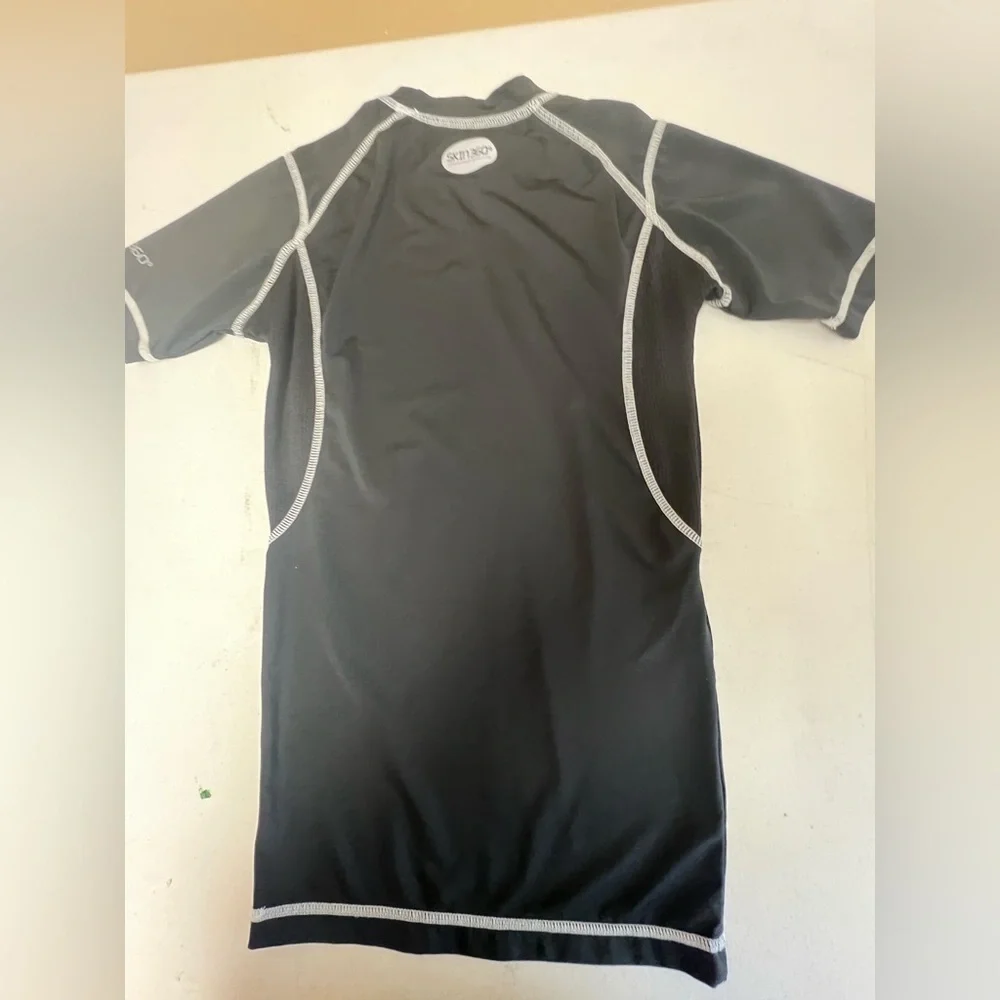 SKIN 360 BOYS BLACK SHORT SLEEVE TOP W/WHITE STITCHING. AGE 13-14. .